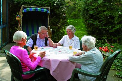 Menschen spielen auf der Terrasse im Strandkorb